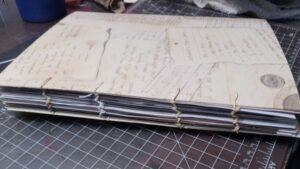 Side view of art journal, shows binding stitches.